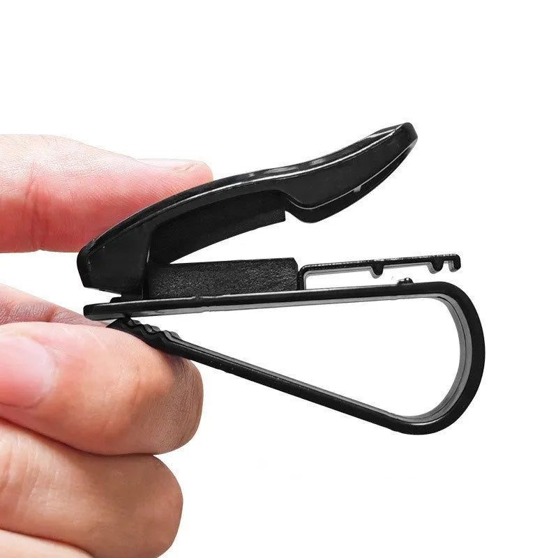 Black plastic car sunshade clip for holding glasses and cards on a vehicle visor.