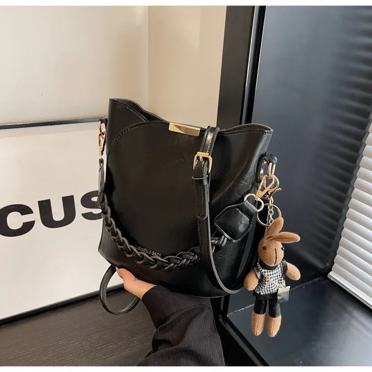 Women's retro bucket messenger bag in PU leather, 21x11x21 cm, with pendant detail and double shoulder strap connector