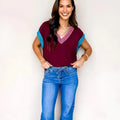 Burgundy women's loose sweater with V-neck, contrast trim, and cuffed short sleeves