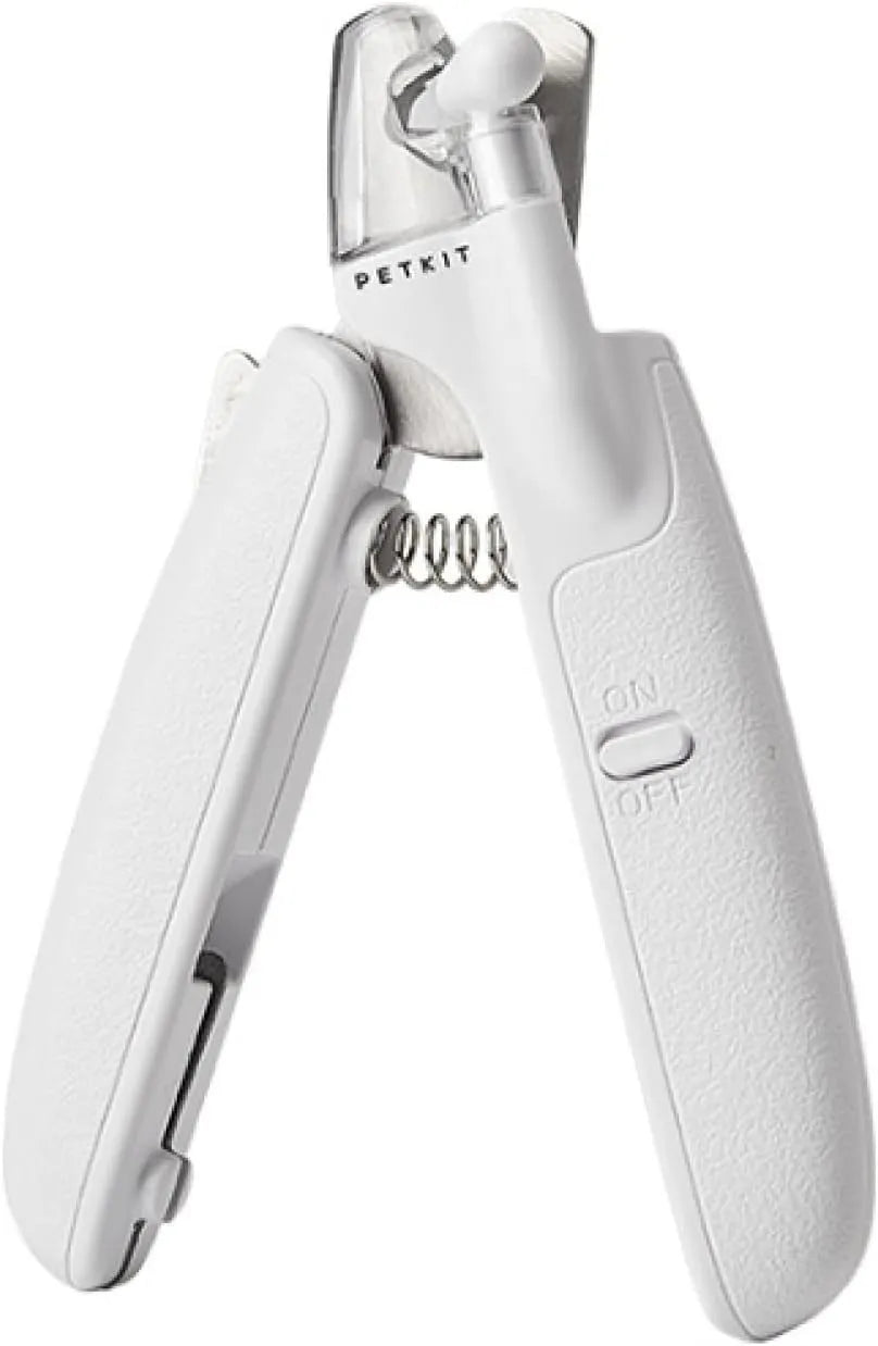 White pet nail clippers with LED light, anti-splash guard, and a nail file on a table.