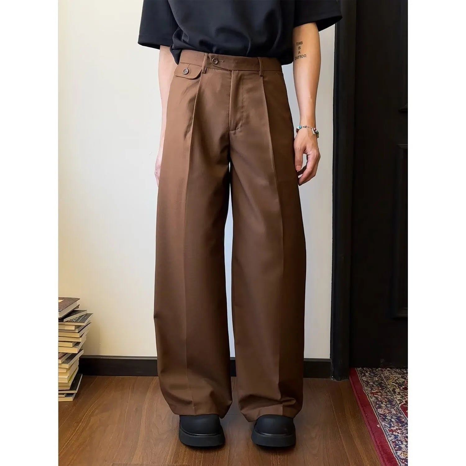 Men's straight-leg loose-fit trousers in brown and black colours on a hanger.