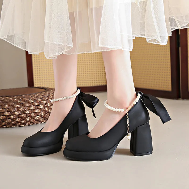 Beige women's Mary Jane shoes with a chunky heel, round toe, and ankle strap with a pearl and buckle.