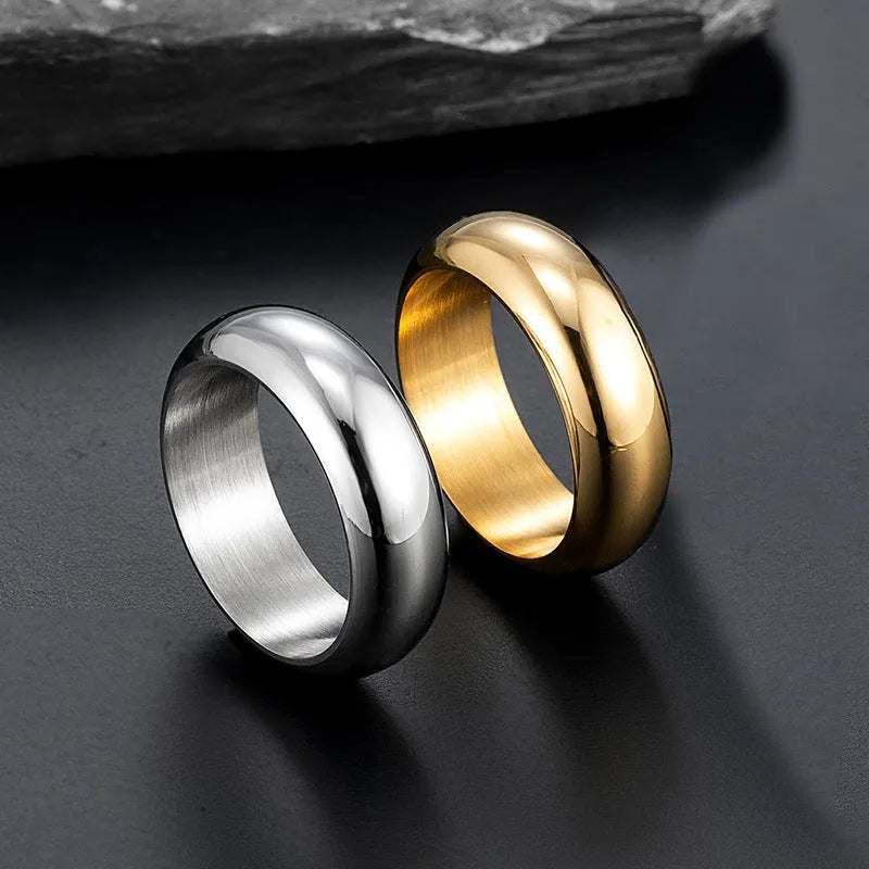 Glossy electroplated titanium steel ring in gold, black, and steel colours on a grey background.