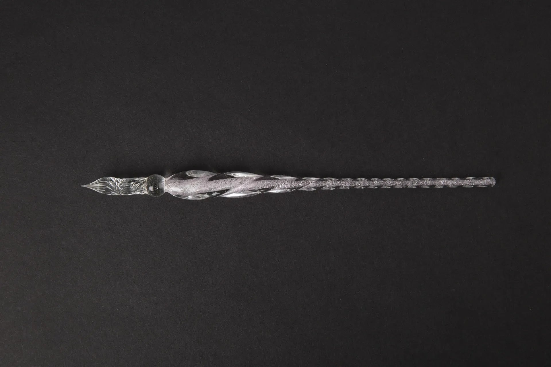 Hand-blown glass crystal pen with coloured ink in a transparent barrel on a gift box.