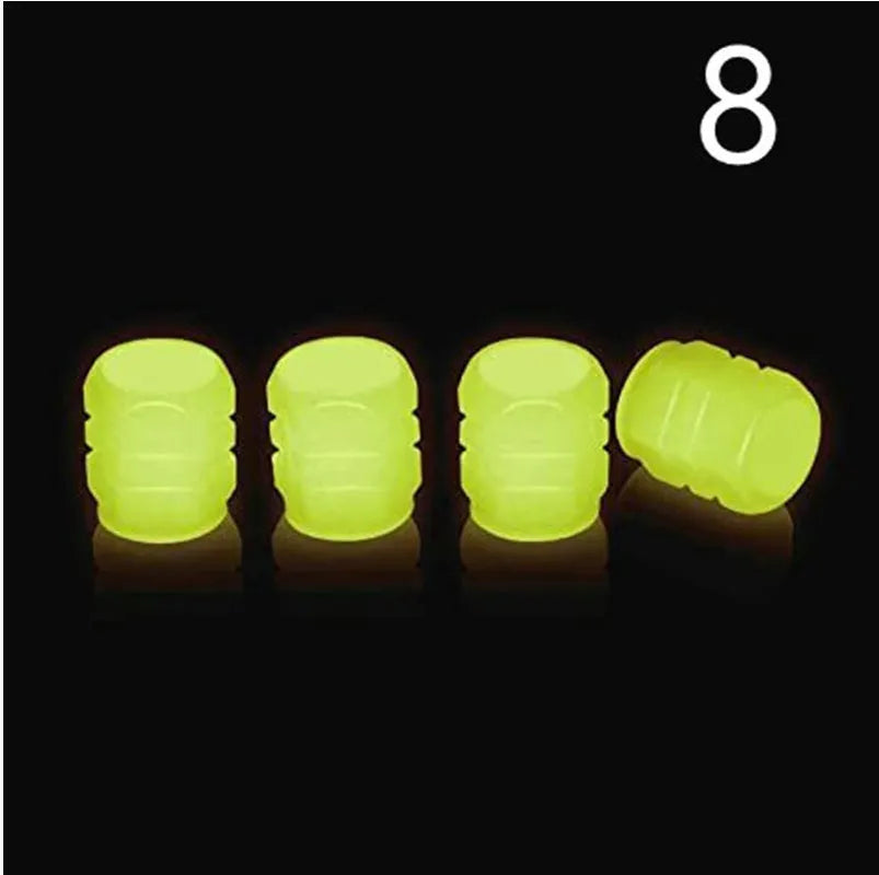 Pack of green and blue luminous rubber tyre valve caps on a car tyre valve.