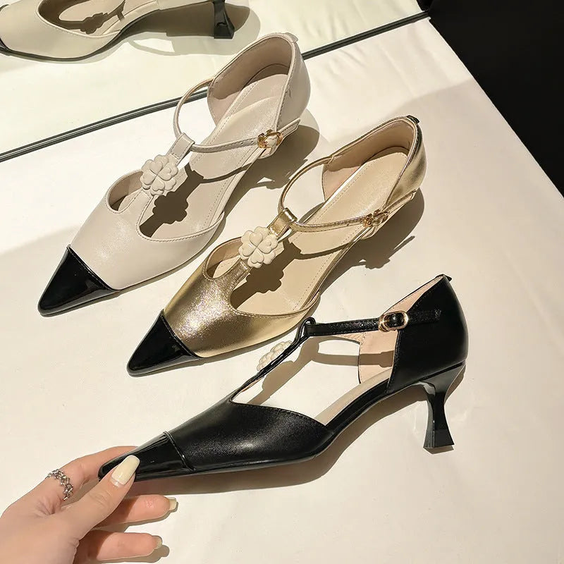 Gold women's stiletto heel shoe with pointed toe, flower buckle, and shallow mouth cut on a beef tendon sole.