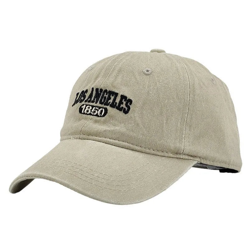 Adult personalised embroidered peaked cap in beige with adjustable strap and distressed lettering.