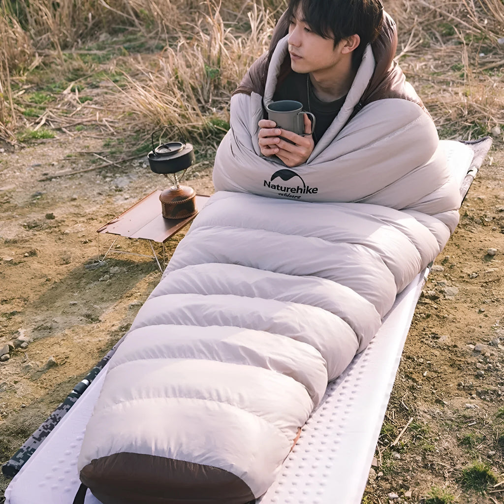 Goose down mummy style sleeping bag for adults with a storage bag.