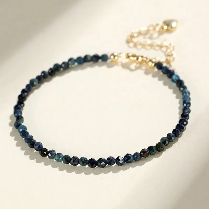 3mm blue tourmaline cut bead bracelet with spacer beads on a wrist