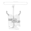 A white adjustable table lamp on a bookshelf with a flexible arm, showing a reading light in use.