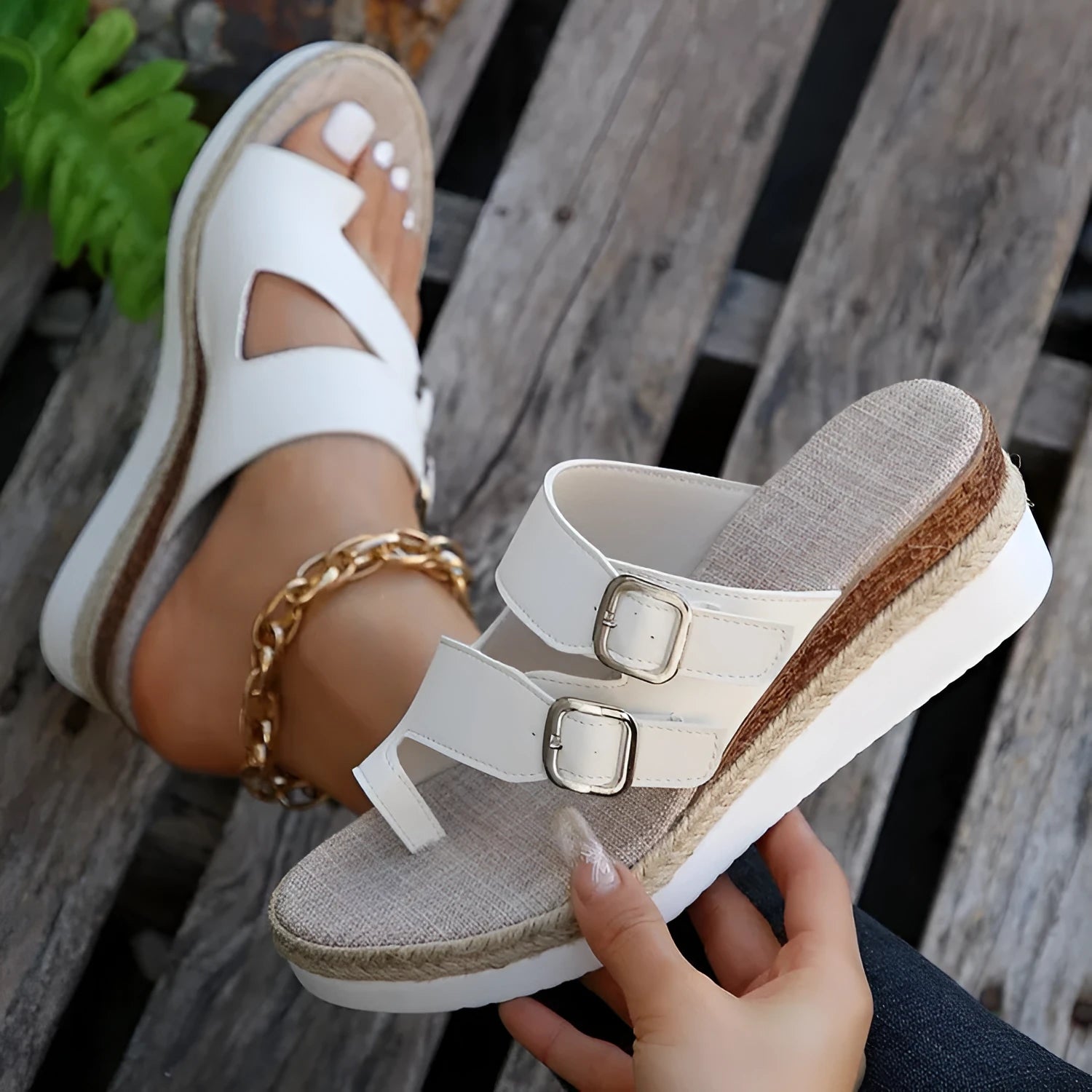 White patent leather wedge sandals with woven upper and peep toe design on a neutral background