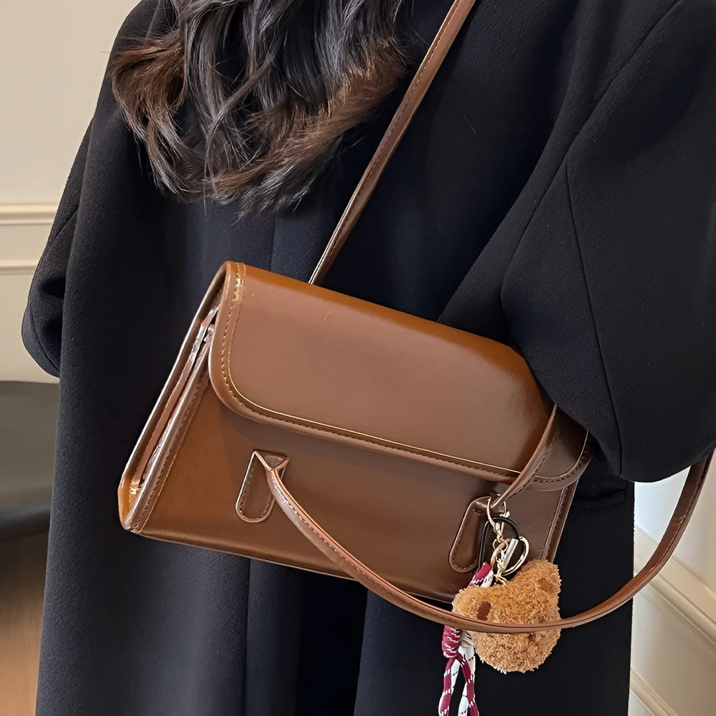 Brown women's PU leather shoulder bag with a square shape, double straps, and a detachable pendant.