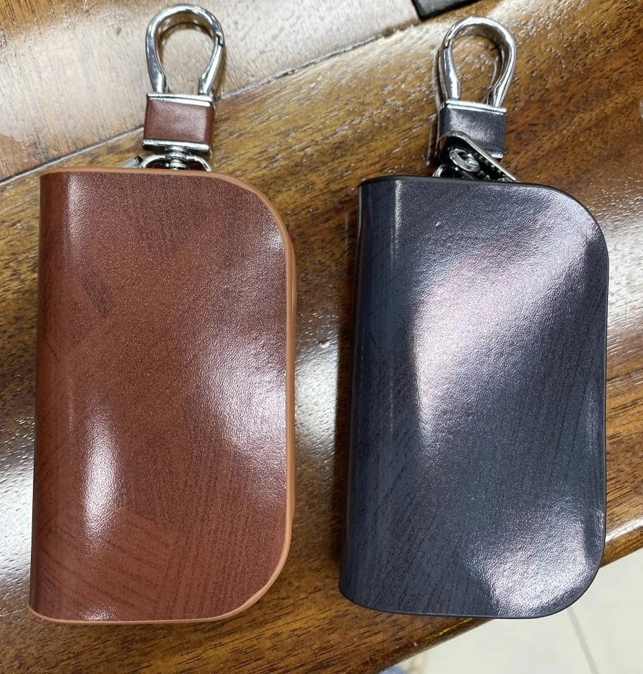 Genuine leather car key case with zipper in black and brown frosted finish.