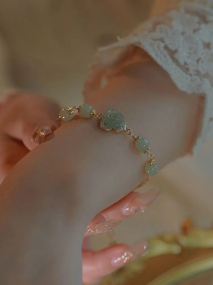 Women's Hetian Jade bracelet with carved rose design and 14K gold gilding on floral-shaped band