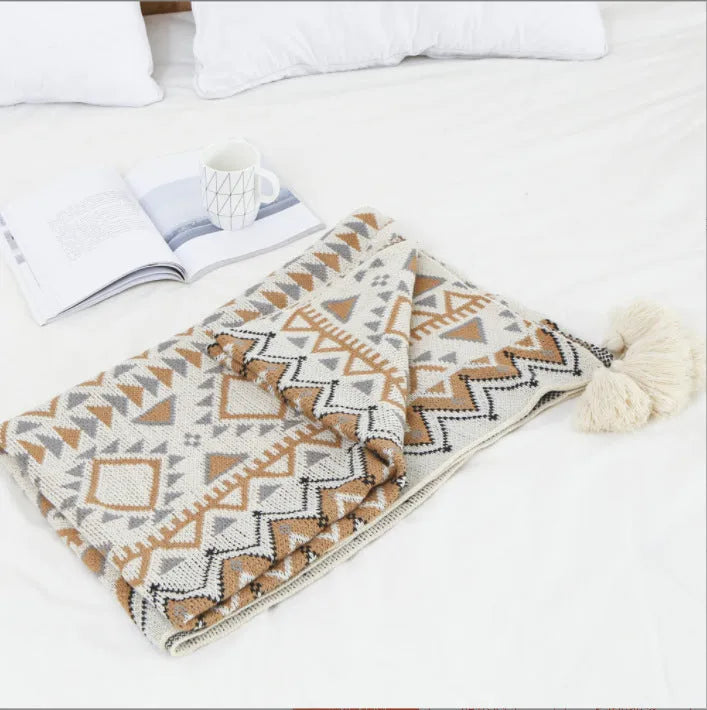 Acrylic sofa blanket with tassels in geometric pattern colour option on a sofa