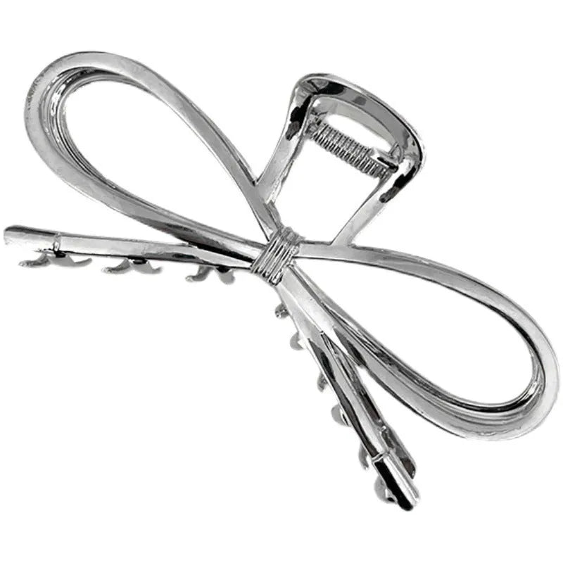A silver and a gold alloy hair barrette with a prominent bow design.