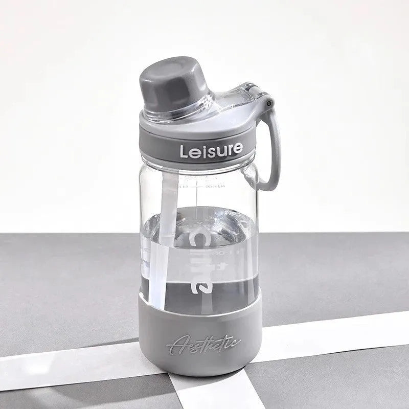 Grey plastic straw cup showing integrated straw and cylindrical shape on a table.