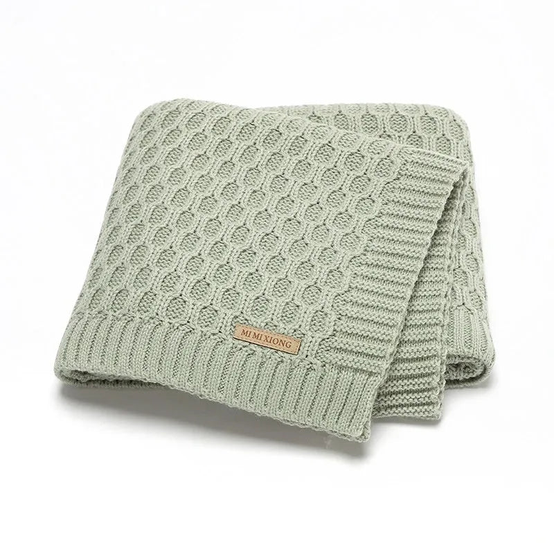 Solid colour acrylic infant hug blanket with textured lines, shown in beige khaki colour.