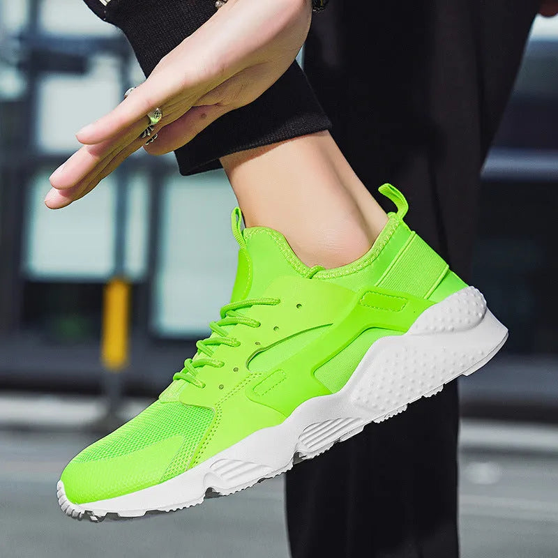 Men's green low top mesh casual shoes with lace-up front and cross straps on a flat sole.