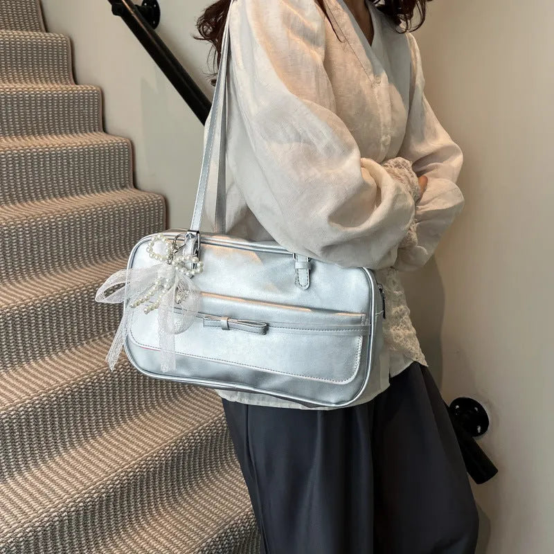 Single-shoulder flap bag in horizontal square shape with bow decoration and internal phone compartment