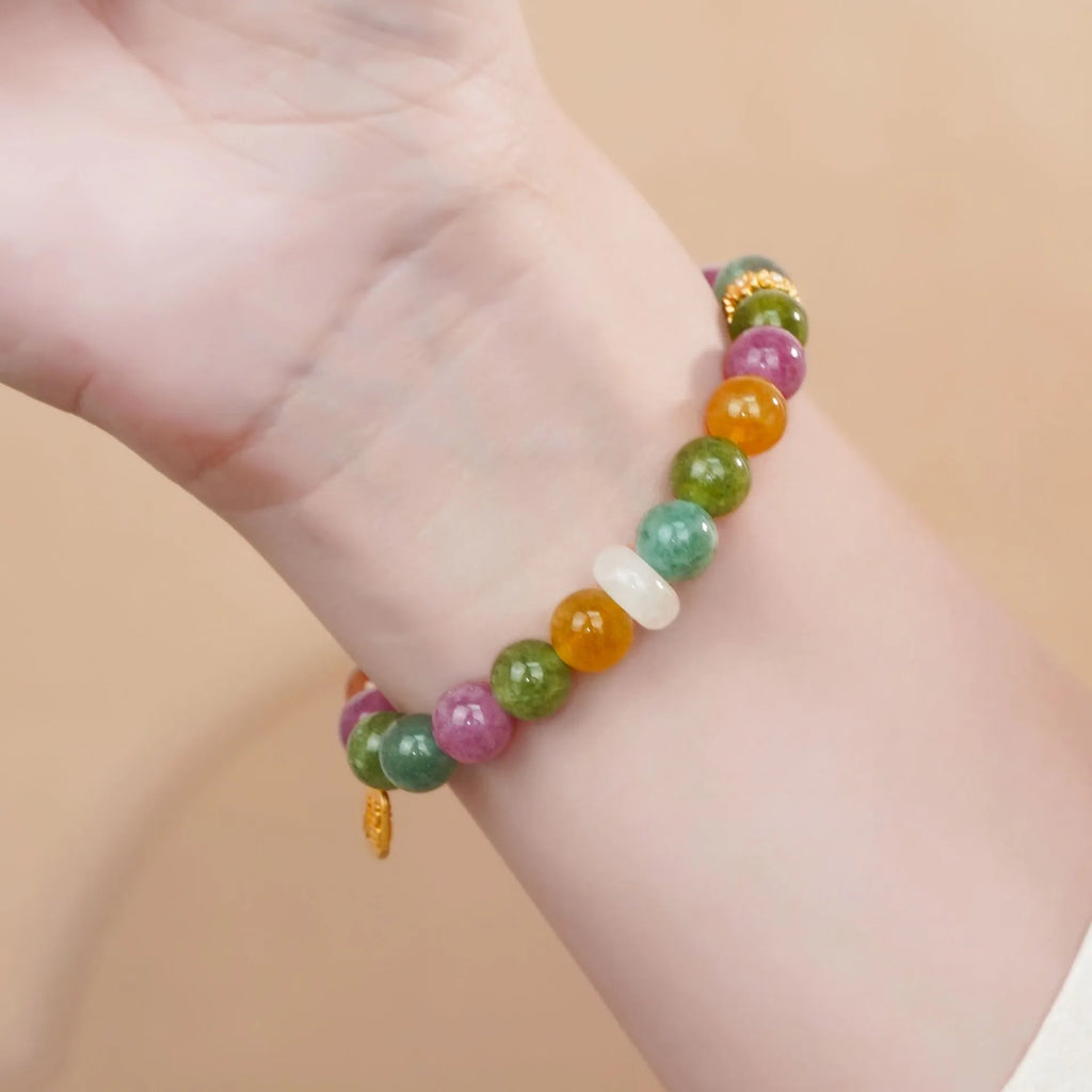 Rainbow coloured tourmaline half bracelet for women on a wrist, showing electroplated finish.