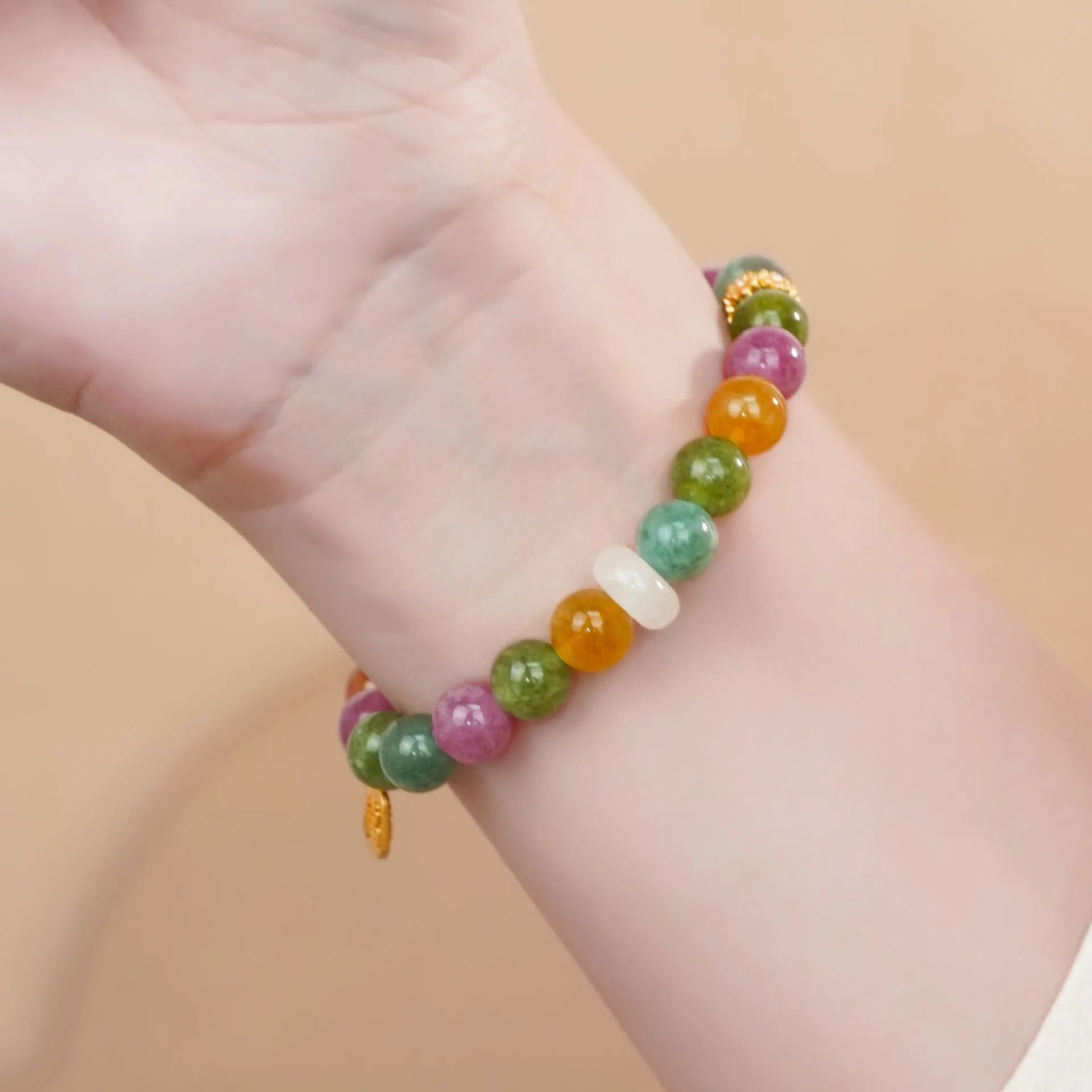 Rainbow coloured tourmaline half bracelet for women on a wrist, showing electroplated finish.