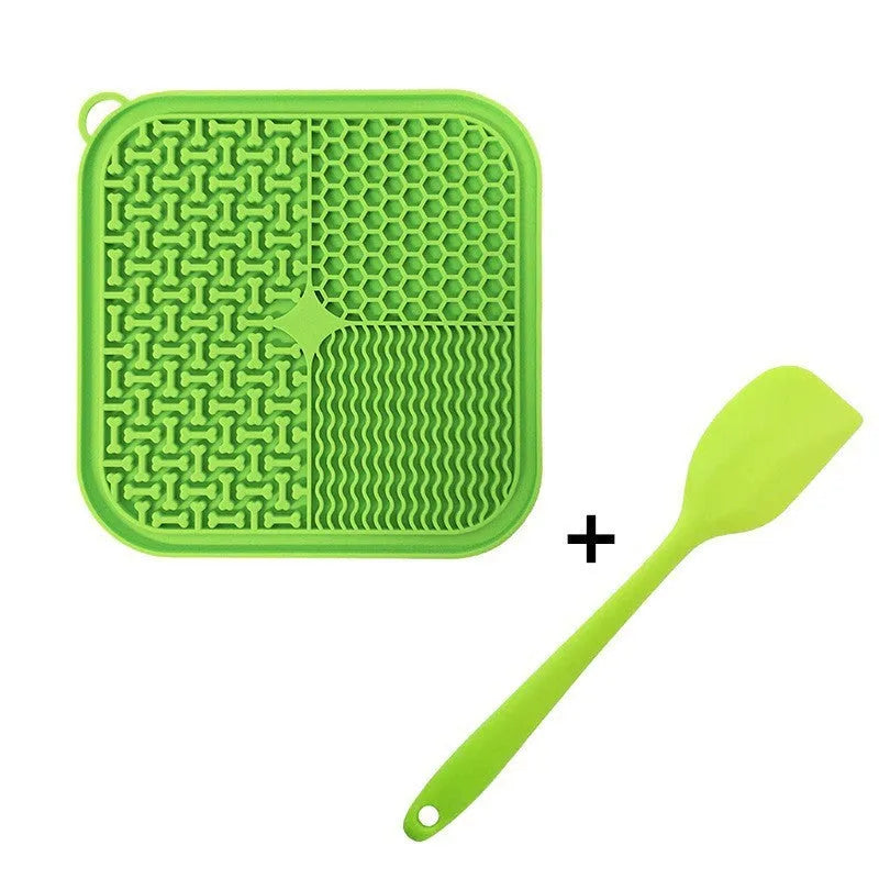 Orange, grey, blue, and green silicone dog licking mat with suction cups on a smooth surface.