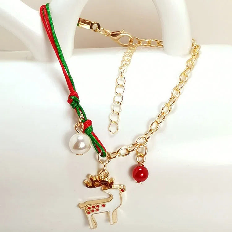 Christmas charm bracelet with alloy chain and festive pendant charms on light background