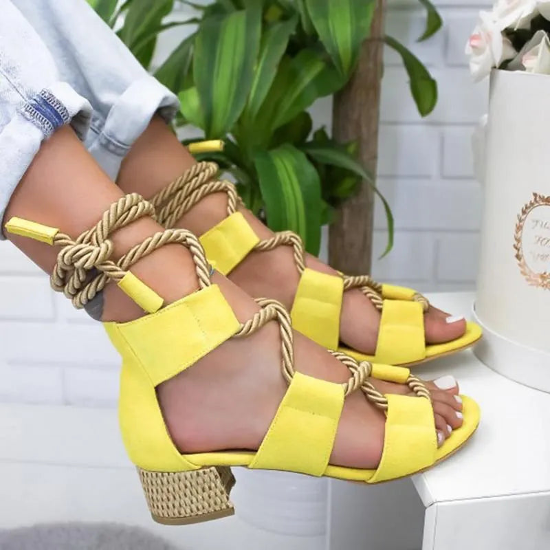 Women's beige suede sandals with fish-mouth toe, colour-matched pattern, and ankle strap on a thick heel.