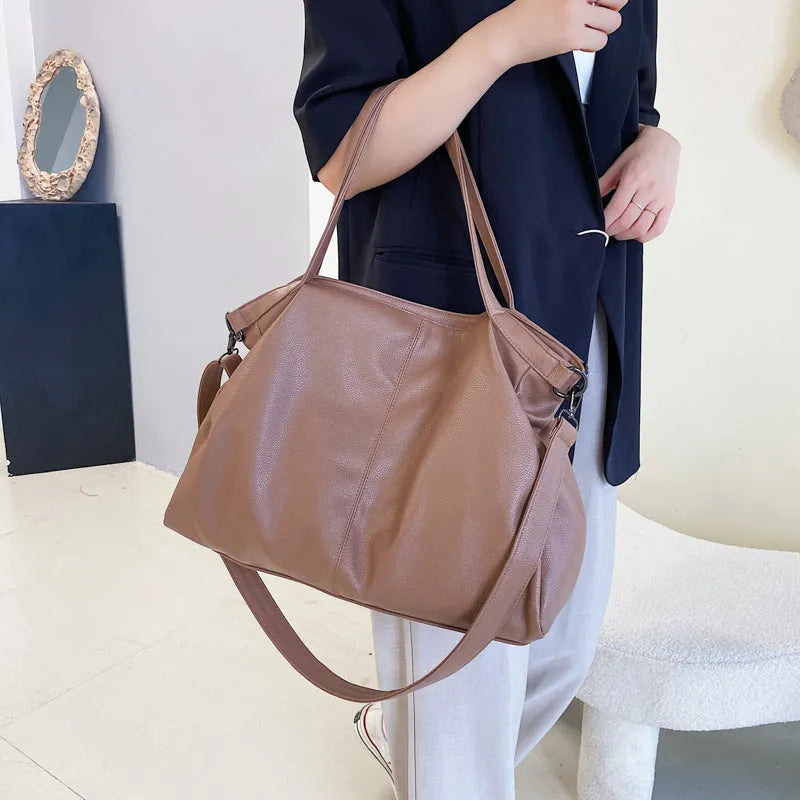 Large black PU leather messenger bag with shoulder strap showing internal organisation pockets