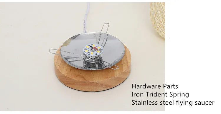 Handmade brown hemp rope spherical desk lamp with a solid wood base on a desk.