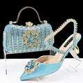 Women's high heel shoes with matching clutch bag featuring decorative flower buckle and ankle chain detail