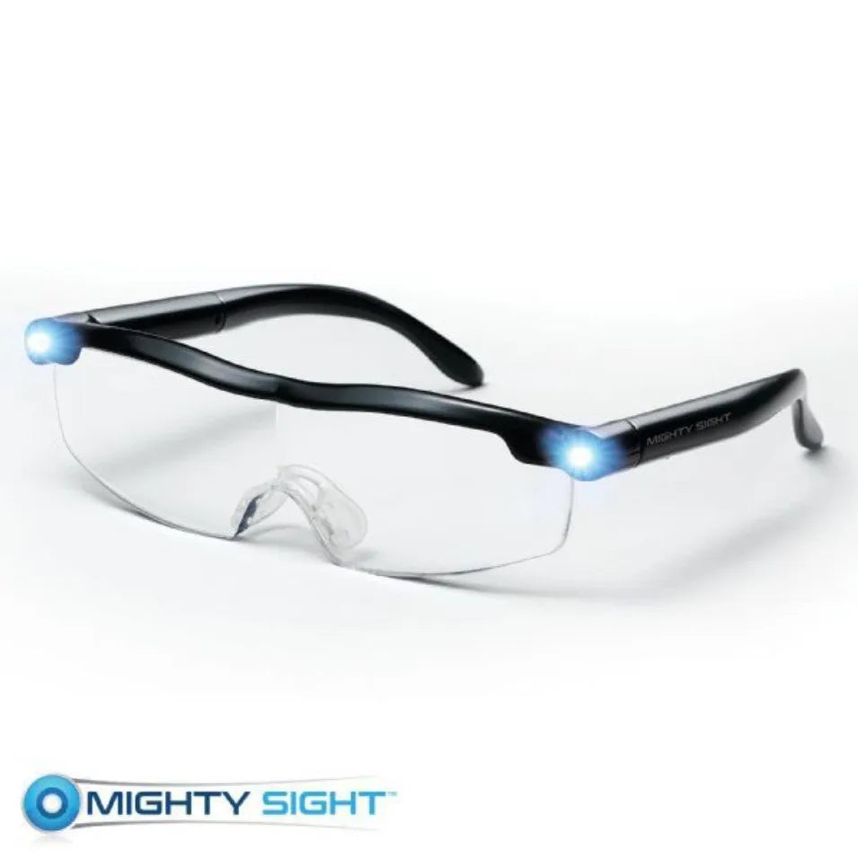 Transparent black USB LED light reading glasses on a table, showing the built-in light and frame.