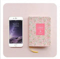 Green fabric imitation leather floral notepad open on a desk, showing custom logo printing and Daolin paper.