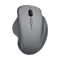 Black wireless laptop mouse with USB-C charging cable on desk next to laptop
