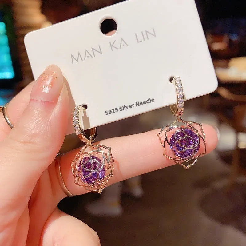 A pair of women's geometric copper earrings with a rose design and small zircon stone accents.
