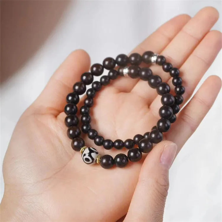 Solid ebony wood bracelet with 8mm Tibetan beads showing two-circle pattern