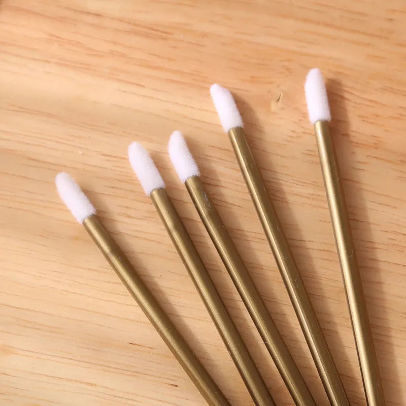 Pack of disposable lip brush wands with flocked brush tips and coloured handles.
