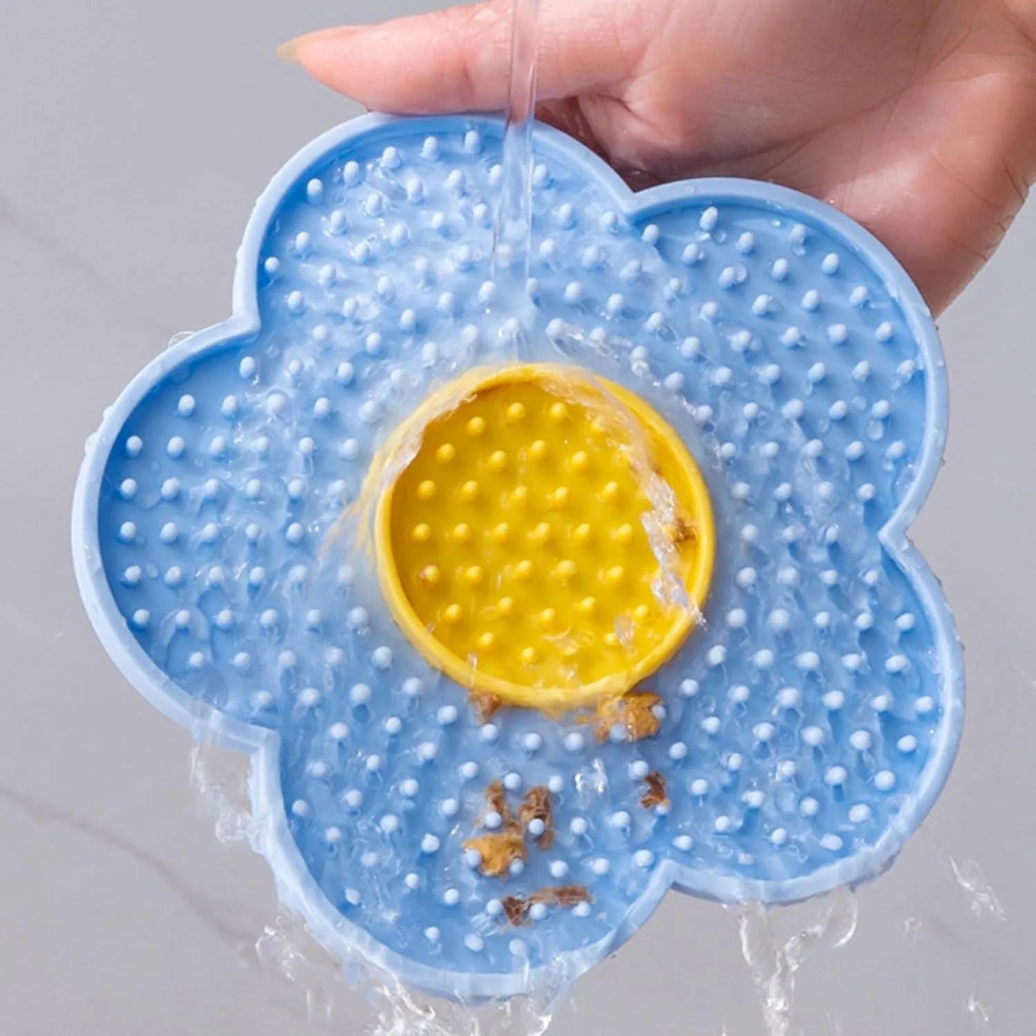 Flower-shaped silicone lick pad for cats and dogs with multiple suction cups on the back, shown in a choice of colours.