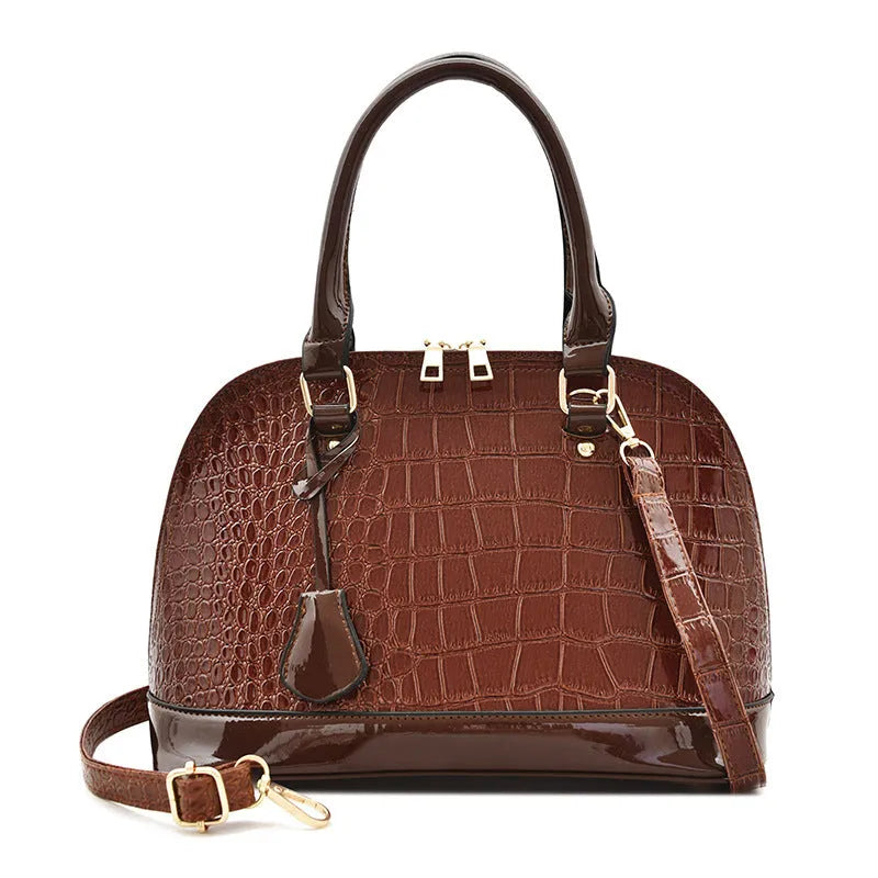 Shiny black PU crossbody bag with a structured shell shape and an adjustable strap.