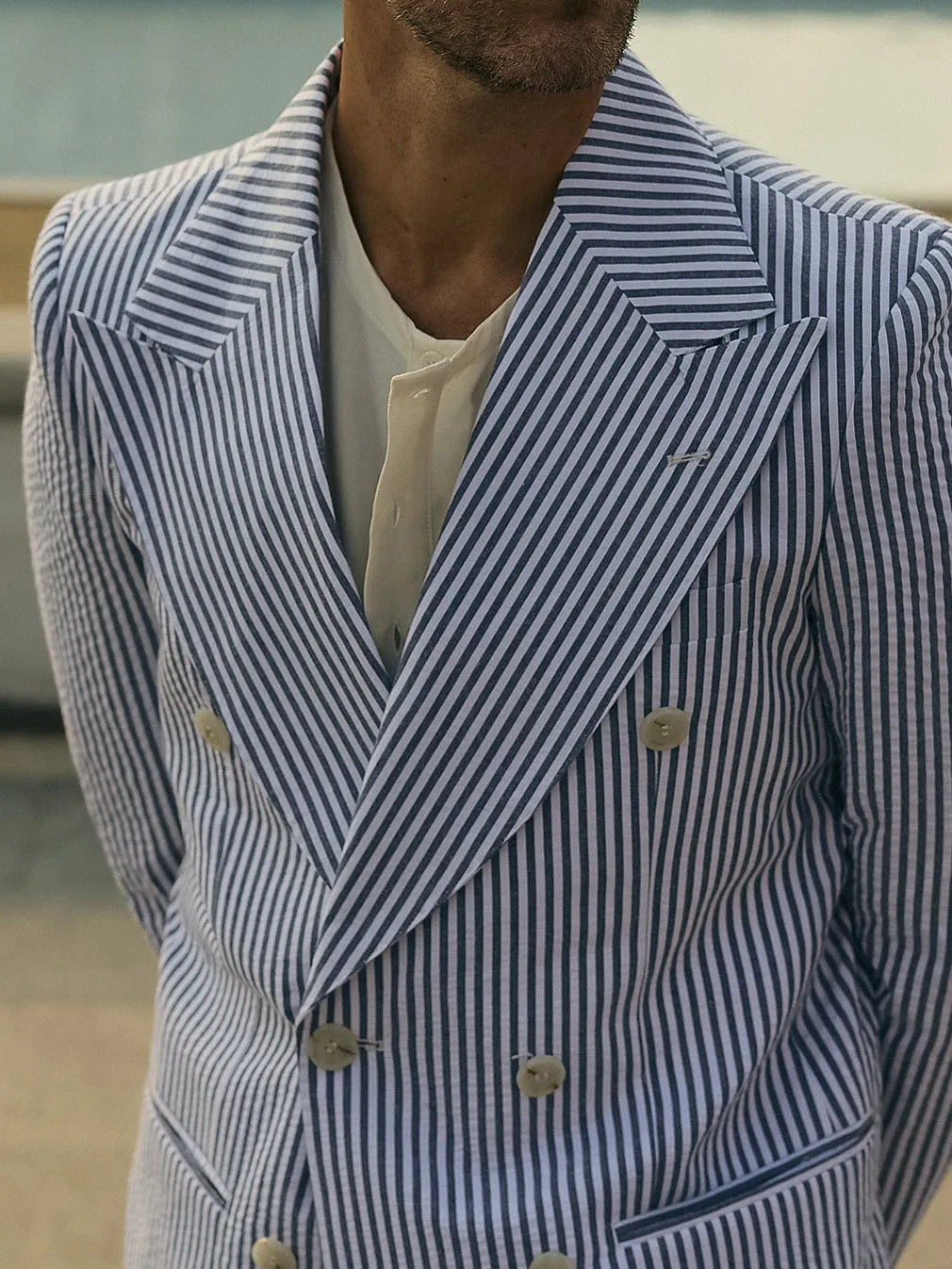 Blue and white striped polyester two-piece suit set with blazer and trousers on a hanger.