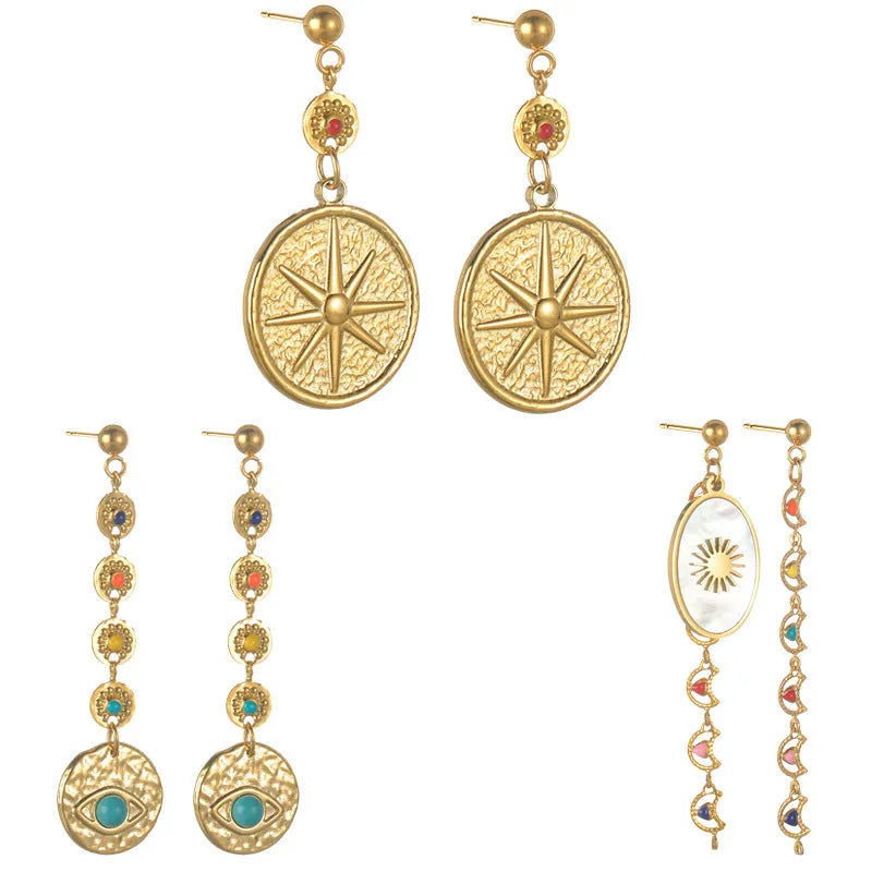 Three pairs of geometric stainless steel earrings: star, eye, and shell sun designs.