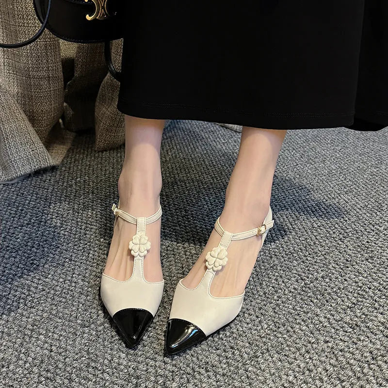 Gold women's stiletto heel shoe with pointed toe, flower buckle, and shallow mouth cut on a beef tendon sole.
