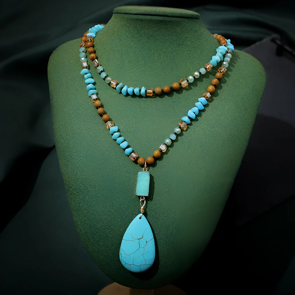 Turquoise blue water drop pendant necklace with geometric shapes on a long ball bead chain.
