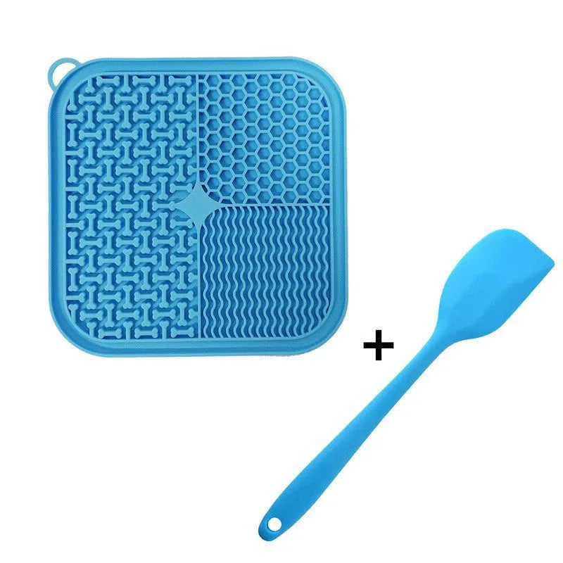 Orange, grey, blue, and green silicone dog licking mat with suction cups on a smooth surface.