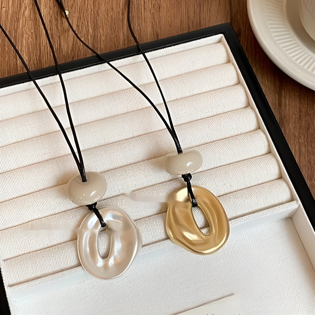 Geometric bow pendant necklace in gold alloy with artificial crystal accents on ladies long chain