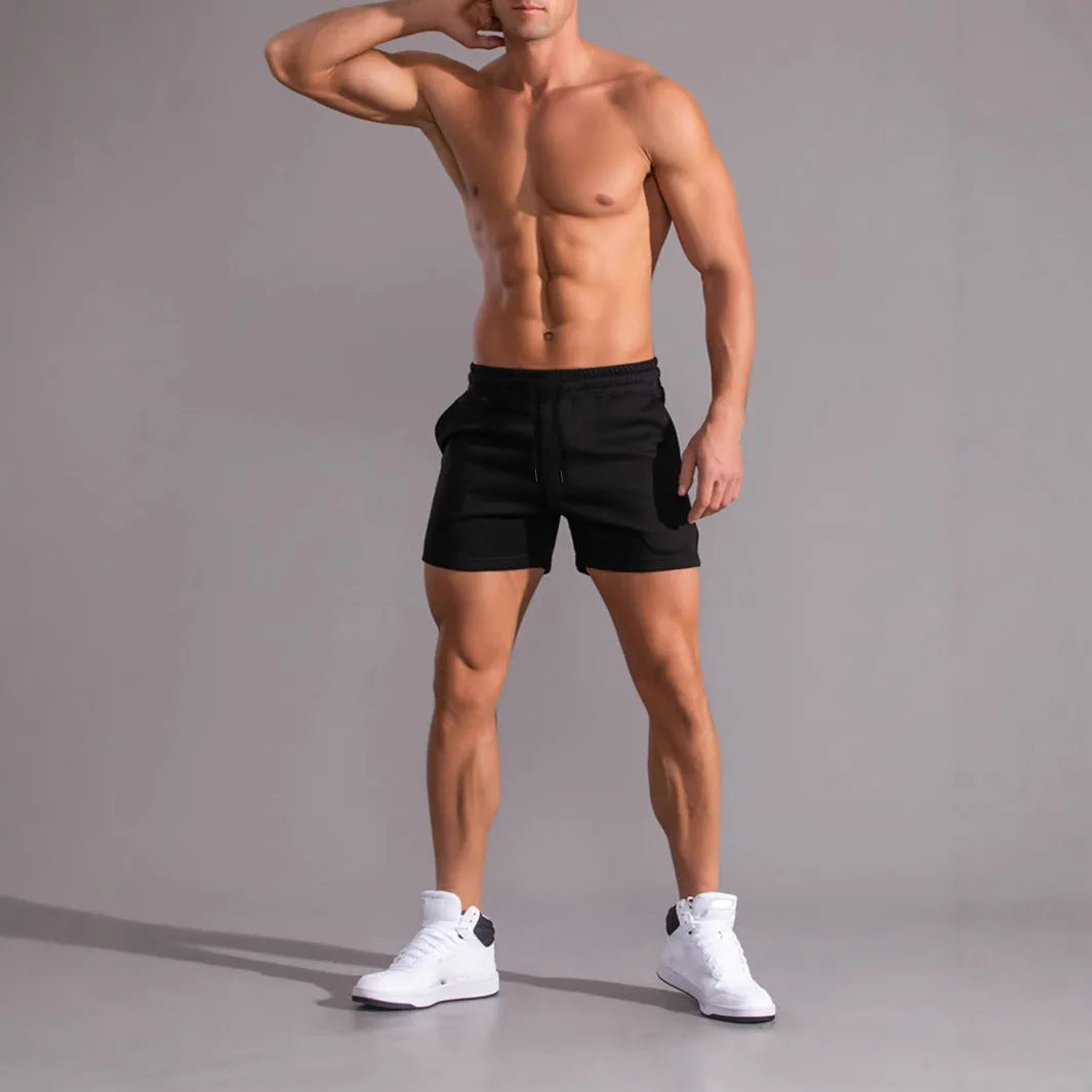 Three pairs of men's solid colour drawstring shorts in a pack, shown in black, khaki, and light brown.
