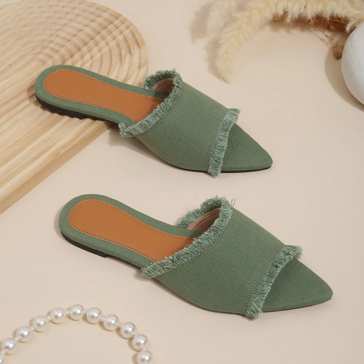 Women's denim flat slippers with a tassel, leather lining, and a PVC sole in various colours.