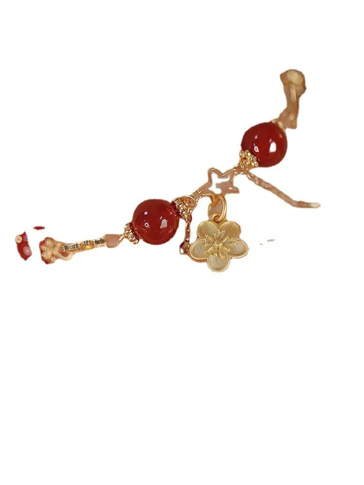 Red agate double layer women's bracelet with peach blossom design on adjustable string.