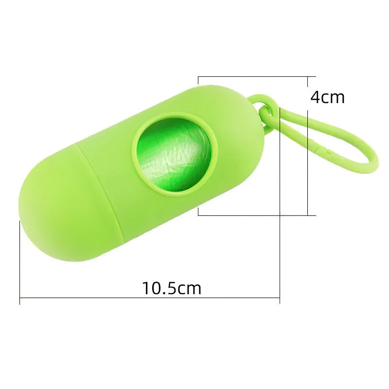 Compact black dog poop bag holder with hook and Velcro strap, shown attached to a pair of trousers.